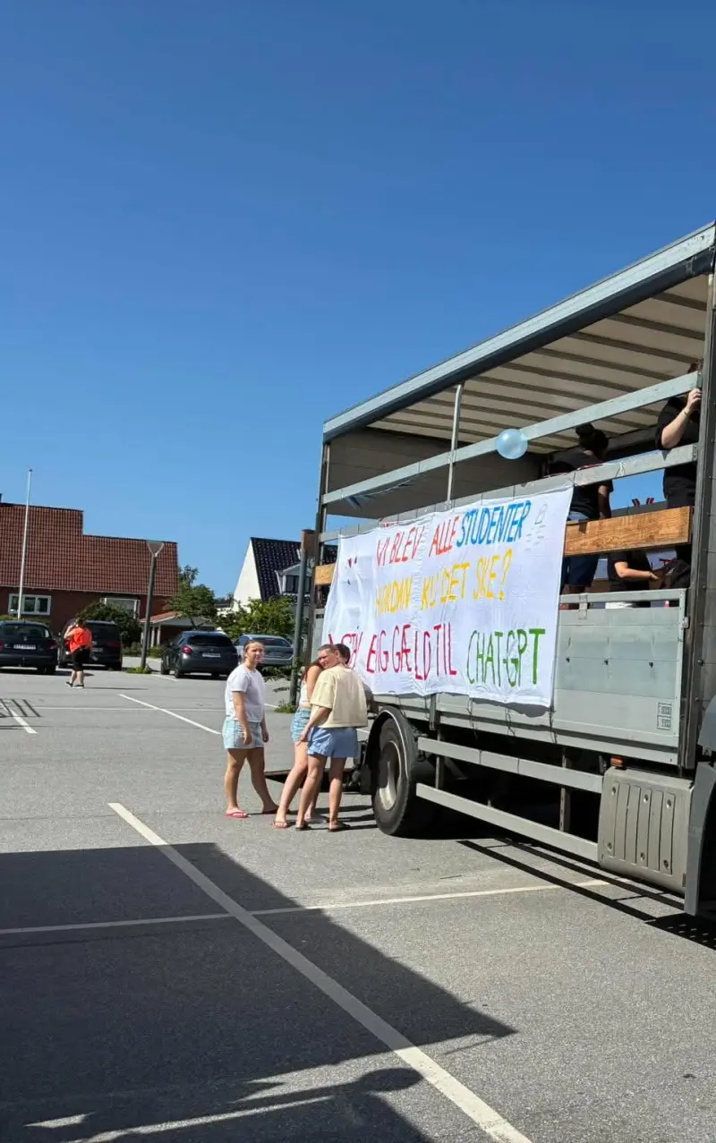 Studentervogn med selvlavet banner på parkeringsplads